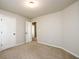 Neutral bedroom with tan carpet, white doors, and open doorway at 103 Magnaview Dr, Mcdonough, GA 30253