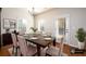 Dining room with a dark wood table, seating for six, and natural light from large windows at 103 Magnaview Dr, Mcdonough, GA 30253