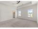Spacious, carpeted bedroom with tray ceiling, ceiling fan, and ensuite bathroom at 1937 Quarry Park Nw Pl, Atlanta, GA 30318