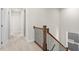 Upstairs hallway featuring neutral walls and carpet with wood railing and black iron balusters at 1937 Quarry Park Nw Pl, Atlanta, GA 30318