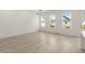 Bright, spacious living room features light wood floors, three windows, and modern lighting fixture at 1937 Quarry Park Nw Pl, Atlanta, GA 30318