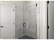 Modern bathroom featuring a frameless glass shower door and elegant marble-look tile at 1941 Quarry Park Nw Pl, Atlanta, GA 30318