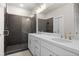 Modern bathroom featuring double sinks, white cabinets, and tiled shower with glass door at 1941 Quarry Park Nw Pl, Atlanta, GA 30318