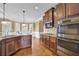 Spacious kitchen with dark wood cabinets, granite countertops, stainless steel appliances, and a breakfast nook at 2040 Browning Bend Ct, Dacula, GA 30019