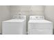 Functional laundry area equipped with a white washer and dryer set for convenient laundry tasks at 2040 Browning Bend Ct, Dacula, GA 30019