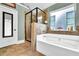Luxurious bathroom with a separate glass-enclosed shower and a soaking tub under a window at 2040 Browning Bend Ct, Dacula, GA 30019