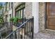 Close-up of a brick townhome's facade, featuring a wrought iron railing and lush greenery at 8 Honour Nw Ave # 6, Atlanta, GA 30305