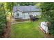 An aerial view of the fenced back yard, shed, back deck and surrounding mature trees at 152 Country Cottage Cir, Carrollton, GA 30116