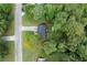 An aerial view of a charming home surrounded by mature trees and a well-manicured lawn at 152 Country Cottage Cir, Carrollton, GA 30116