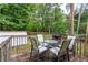 A wooden back deck features seating and a view to the grassy back yard at 152 Country Cottage Cir, Carrollton, GA 30116