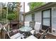 A cozy back deck features a glass table, seating and a view to the back yard at 152 Country Cottage Cir, Carrollton, GA 30116