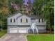 Two story home with light gray siding, black shutters, two-car garage and landscaping at 152 Country Cottage Cir, Carrollton, GA 30116