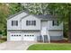 Two story home with light gray siding, black shutters, and front landscaping at 152 Country Cottage Cir, Carrollton, GA 30116
