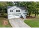 A two-story home has an attached two-car garage and a cozy front porch at 152 Country Cottage Cir, Carrollton, GA 30116