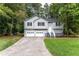 Two story home with light gray siding, black shutters, two-car garage and front landscaping at 152 Country Cottage Cir, Carrollton, GA 30116