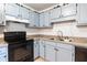 Charming kitchen features blue cabinets, a black range, and neutral countertops at 152 Country Cottage Cir, Carrollton, GA 30116