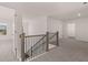 Bright upstairs hallway features neutral walls, carpet, and a wood and iron railing staircase at 1858 Lacebark Elm Way, Lawrenceville, GA 30045