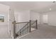 Spacious carpeted hallway with white walls, a wooden staircase railing, and bright natural light at 1858 Lacebark Elm Way, Lawrenceville, GA 30045