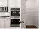 Kitchen featuring stainless ovens and a walk-in pantry at 1858 Lacebark Elm Way, Lawrenceville, GA 30045
