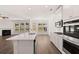 Open kitchen with island, stainless appliances, and a fireplace in the living room at 1858 Lacebark Elm Way, Lawrenceville, GA 30045