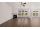 Bright living room with a fireplace, hardwood floors, and large windows overlooking the backyard at 1858 Lacebark Elm Way, Lawrenceville, GA 30045