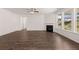 Open living area featuring hardwood floors, modern fireplace, and abundant natural light from large windows at 1858 Lacebark Elm Way, Lawrenceville, GA 30045
