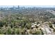 Aerial view features property in a lush, wooded neighborhood with distant skyline at 348 Lakemoore Ne Dr, Atlanta, GA 30342