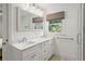 Bright bathroom featuring a double sink vanity, framed mirror, and a tiled shower at 348 Lakemoore Ne Dr, Atlanta, GA 30342