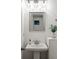 Stylish bathroom featuring a pedestal sink, modern fixtures, and decorative accents at 348 Lakemoore Ne Dr, Atlanta, GA 30342