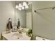 Well-lit bathroom featuring a vanity with modern fixtures and a decorative mirror at 2389 Lake Villas Ln, Duluth, GA 30097