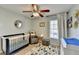 Bedroom featuring baby bed and changing table, modern ceiling fan, and bright window at 2389 Lake Villas Ln, Duluth, GA 30097