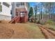 Backyard view featuring an elevated deck, mature trees, and sloped lawn at 2452 Lakebrooke Dr, Marietta, GA 30066