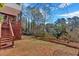 Spacious backyard with mature trees, landscaping, and an elevated deck at 2452 Lakebrooke Dr, Marietta, GA 30066