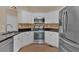 Modern kitchen with white cabinets, granite countertops, stainless steel appliances, and tile backsplash at 2452 Lakebrooke Dr, Marietta, GA 30066