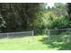 Fenced backyard with green grass and mature trees offering privacy and security at 661 White Bird Way, Fairburn, GA 30213