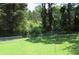 Fenced backyard with green grass and mature trees offering privacy at 661 White Bird Way, Fairburn, GA 30213