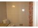 Tiled bathroom featuring a toilet and shower with patterned curtain at 661 White Bird Way, Fairburn, GA 30213