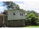 View of the back of the house showcasing brick facade and yard with mature trees at 661 White Bird Way, Fairburn, GA 30213