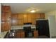 Functional kitchen with wooden cabinets, black appliances, and countertop space for meal preparation at 661 White Bird Way, Fairburn, GA 30213