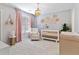 Light and airy Bedroom with crib, rocking chair, chandelier, and pink accents at 1229 Ellington Ct, Cumming, GA 30041