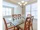 Dining room with a glass top table, chandelier and bright light from the windows at 251 Vinings Retreat Sw Vw, Mableton, GA 30126