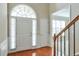 Bright foyer with hardwood floors, transom window, and staircase to upper level at 251 Vinings Retreat Sw Vw, Mableton, GA 30126