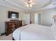 Main bedroom featuring a tray ceiling, large dresser, and bright windows at 251 Vinings Retreat Sw Vw, Mableton, GA 30126