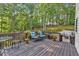 Wooden back deck surrounded by trees and featuring two tables and chairs at 308 Lismore Ter, Woodstock, GA 30189
