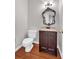 Bathroom features a toilet and vanity with a mirror, cabinet storage, and luxury hardwood floors at 308 Lismore Ter, Woodstock, GA 30189