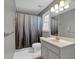 Bathroom featuring a single sink vanity, window, toilet, and tub with shower at 308 Lismore Ter, Woodstock, GA 30189