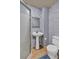 Bathroom with pedestal sink, toilet, and shower with blue wallpaper at 308 Lismore Ter, Woodstock, GA 30189