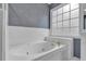 Bathroom showcases a modern white bathtub, luxury gold fixtures, and a large window for natural light at 308 Lismore Ter, Woodstock, GA 30189