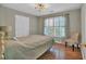 Cozy bedroom featuring wood floors, neutral colors, and a window providing natural light at 308 Lismore Ter, Woodstock, GA 30189