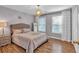 Well-lit bedroom featuring a large bed, hardwood flooring, and neutral paint at 308 Lismore Ter, Woodstock, GA 30189